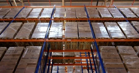 Camera moves between shelves with palettes and boxes in a big modern logistic Stock Footage 109797111