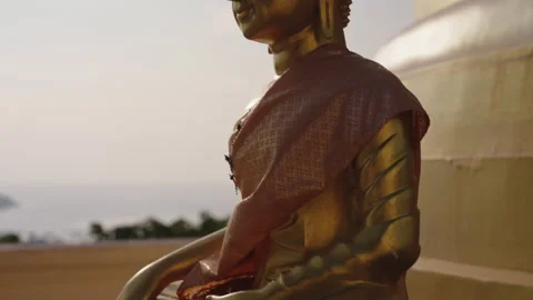 Camera moves from bottom to top along the golden statue of a meditating Buddha Video stock 245986767