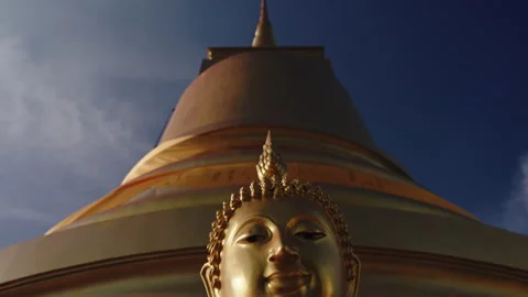 Camera moves from bottom to top of golden sitting Buddha statue on the mountain Stock Footage 250179966