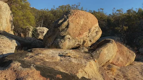 Camera moves from Brown rocks with a sky background down to rocks with lichen Stock Footage 217397380