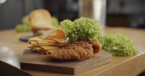 Camera moves to chicken burger on which slice of cheese falls Stock Footage 116606847