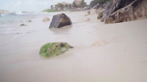 The camera moves close to the beach sand along the coastline, stones close-up. Stock-Footage 128934476