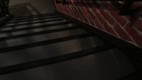 Camera moves down an empty staircase along a brick wall with lamps in the loft Video stock 111812202