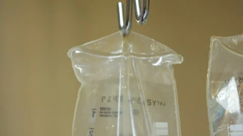 Camera moves down iv bag drip and cord Stock Footage 93663923