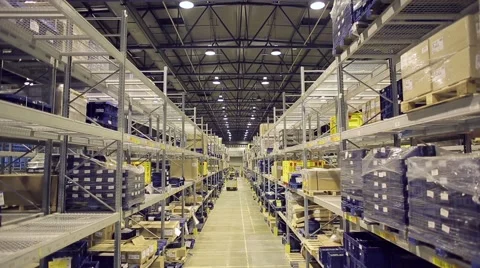 Camera moves down on shelves of cardboard boxes inside a storage warehouse. Stock Footage 61123036