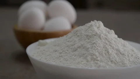 Camera moves the focus from flour to white eggs Stock Footage 88783111