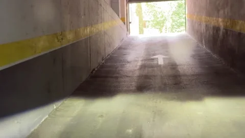 Camera moves forward through parking garage toward outdoor light Stock-Footage 337551483