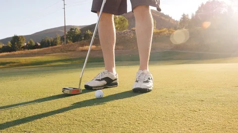 Camera moves with golf ball across green after man putts 스톡 동영상 102670412