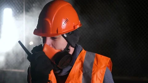 The camera moves left-right. A worker in an orange helmet and overalls shouts Video stock 169509394