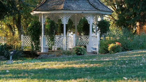 Camera moves low around white gazebo grass Stock-Footage 102670583