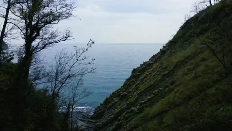The camera moves next to a rock with a view of the sea Stock Footage 171290555