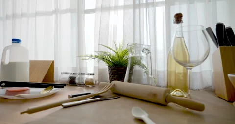 Camera moves over bright home kitchen counter with milk, rolling pin, brush, and Stock Footage 337622902