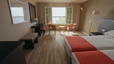 Camera moves over empty room in resort hotel. Beds, table and two chairs. Cozy 스톡 동영상 169146241