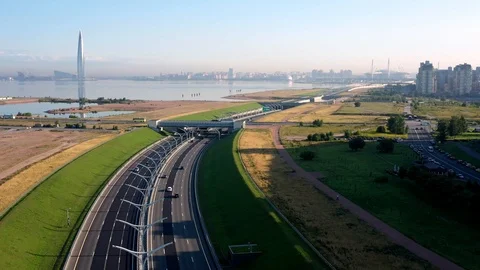 The Camera Moves Over A Modern Highway Against The Skyscraper Stock Footage 117364341