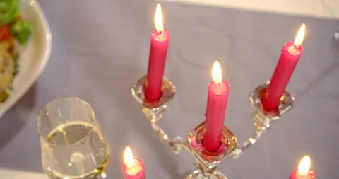 The camera moves over a table in a restaurant with burning candles and a glass Vídeo Stock 130051766
