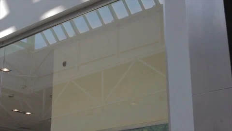 Camera moves past shop window to shopping mall ceiling Video stock 100213793