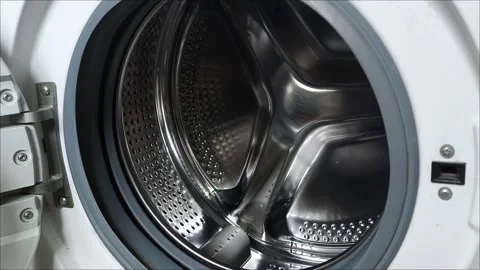 The camera moves from right to left and renders an open washing machine drum. 動画素材 311992915