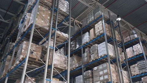 Camera moves up on shelves of cardboard boxes inside a storage warehouse Video stock 74978112