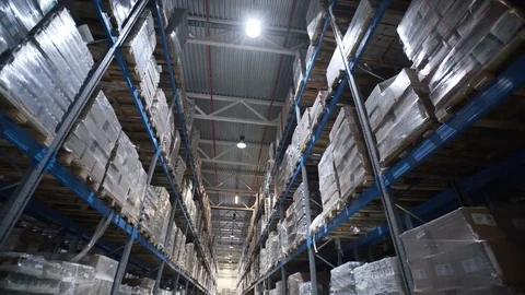 Camera moves up on shelves of cardboard boxes inside a storage warehouse 库存影片 74979260