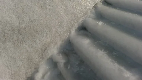 Camera moves up from slippery, ice-covered steps to icy railings against the sea Vídeos de archivo 303081684