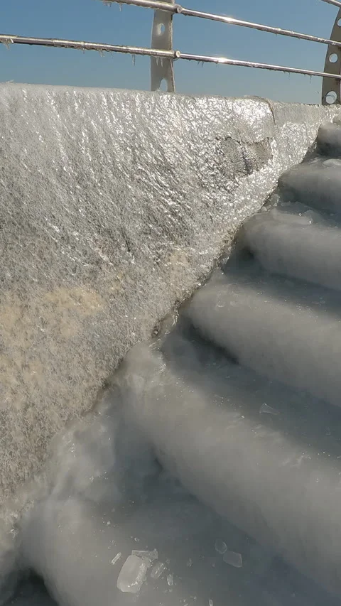 Camera moves up from slippery steps covered with ice-crusted to icy railings Vídeos de archivo 311570221