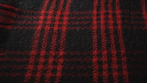 The camera moves slowly along the checkered red-black scarf of synthetic or Video stock 122594169