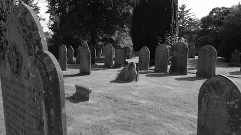 Camera moves slowly between gravestones, English churchyard, black and white Stock Footage 242163139