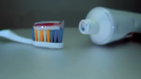 The camera moves slowly next with a new tube of toothpaste and a toothbrush Stock-Footage 130617406