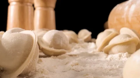 The camera moves slowly through the dumplings and flour. Close-up shot . Black b Видео 144907218