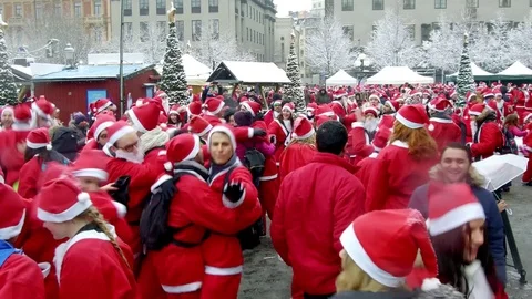 Camera moves smoothly in between crowd of happy Santa Clauses dancing crazy Stock Footage 70638707