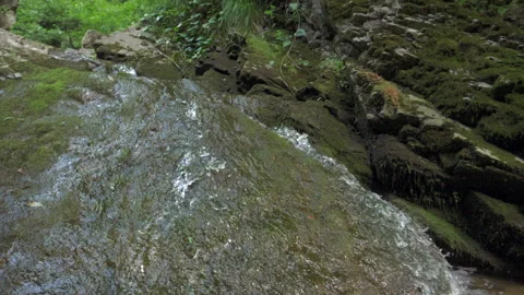 The camera moves smoothly over the rocks to a mountain stream with clear water Video stock 154221643
