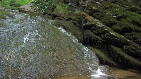 The camera moves smoothly over the rocks to a mountain stream with clear water Stock Footage 154221656