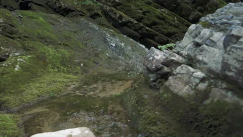 The camera moves smoothly over the rocks to a mountain stream with clear water Stock Footage 154221672