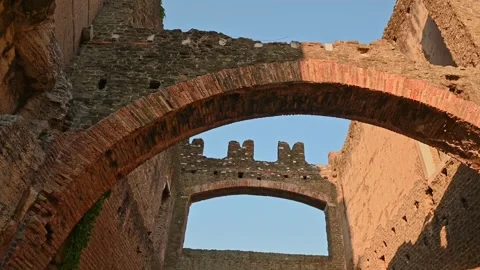 Camera moves through ancient Roman brick arches and ruined stone walls Video stock 347530165