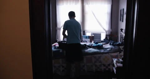 Camera moves through house toward a young man, high school aged boy Stock Footage 231338000
