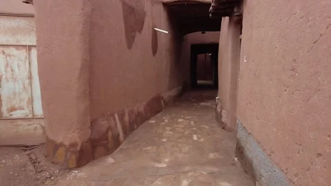 A camera moves through the mudbrick covered streets of Ushaiqer Heritage Village Stock Footage 256072721
