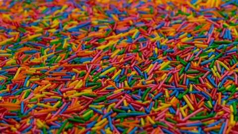 Camera moves vertically thru a heap of colored sugar strands - sprinkles. Stock Footage 91664659