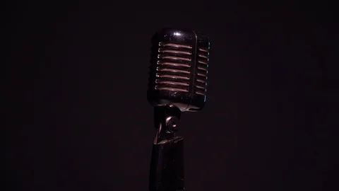 Camera moves up. White spotlights shine on chrome retro mic on black background. Stock Footage 118544203