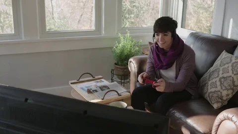 Camera moves as young lady games on her television Stock Footage 70809439