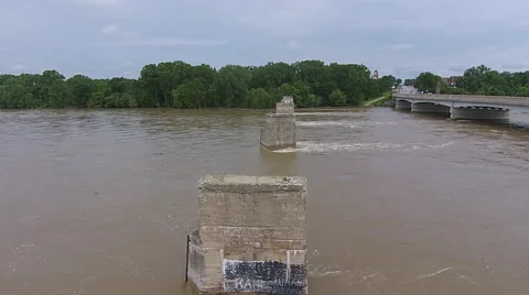 Camera moving across river over old bridge supports Stock Footage 53027704