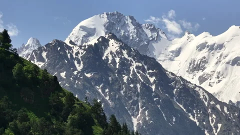 Camera moving along lush forest and showing snow capped mountain Stock-Footage 289672920