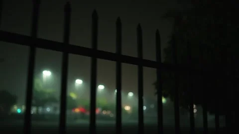 Camera moving along metal fence in fog at night Stock Footage 331226853