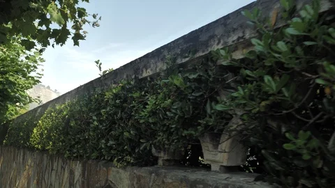 Camera Moving Along the Old Stone Fence in a Yard of Abondaned House in Spain Stock Footage 94593631