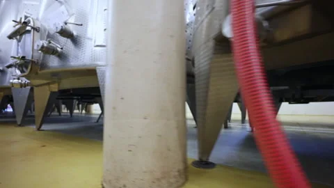 Camera moving along the stainless tanks with attached pipes for different wine Stock Footage 308362782