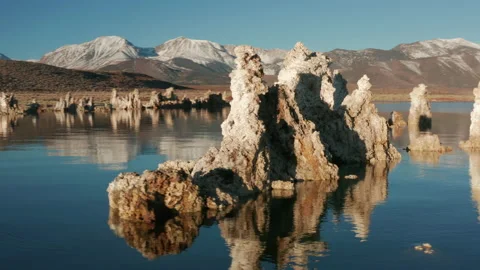 Camera moving around amazing pike stones reflecting in the blue surface, 4K 스톡 동영상 144650143