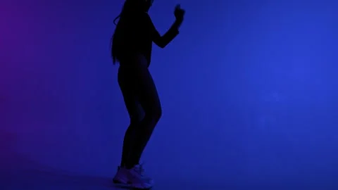 Camera moving around dancer silhouette in blue lit studio Stock Footage 348083371