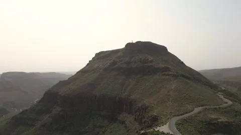 Camera moving around mountain peak with winding road Stock Footage 293158238