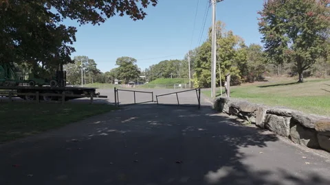Camera moving away from creepy gate in a park on an autumn afternoon Stock Footage 289341953