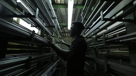 Camera is moving back between almost empty iron shelves in the warehouse of the Stock Footage 126397474