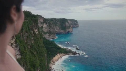 Camera moving between asian people looking to view rocky ocean. Happy Korean Stock Footage 247318827